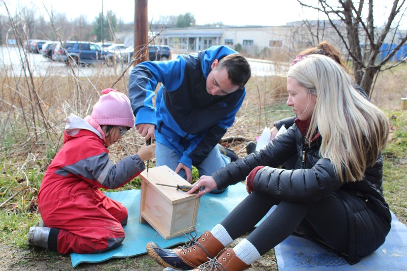 A child works on a birdhouse as part of a program in which College of Education and Human Development students and faculty collaborate with College of Engineering students and faculty to help children learn about birds.