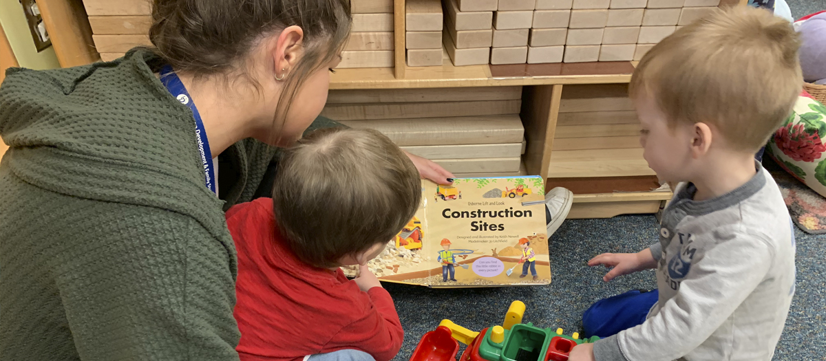 UD education student reads book to two children at the UD Lab School