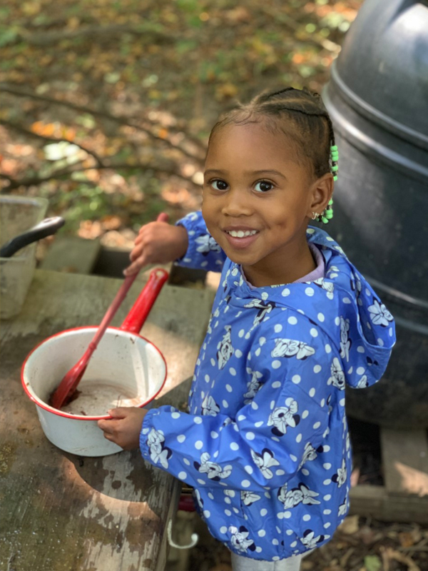 Child using pot in outdoor classroom at the UD Lab School