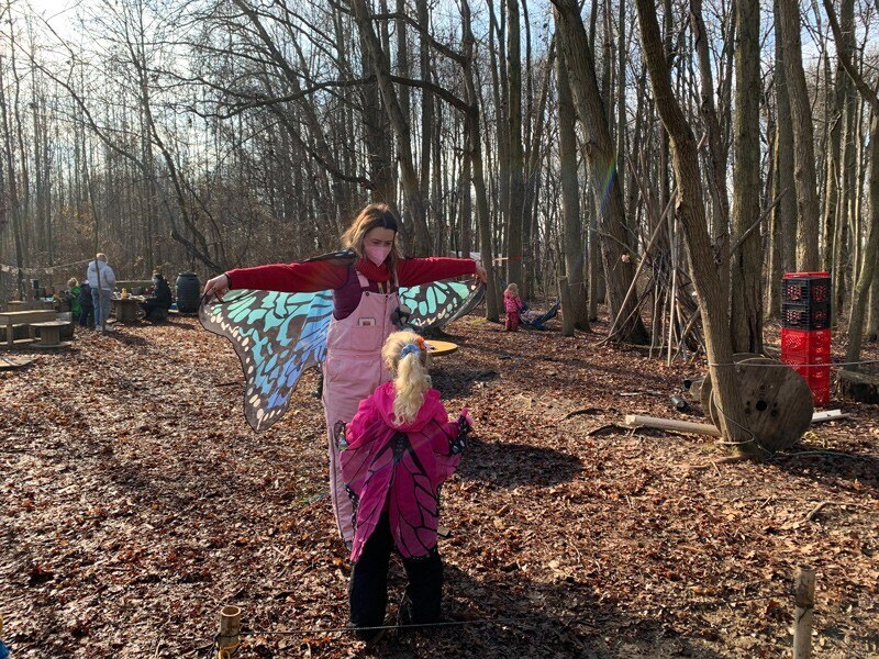 A preschooler learns about butterflies with a UD student outside at CEHD's Lab School.